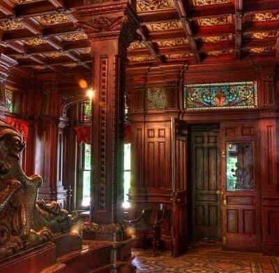 Luxurious wooden interior featuring ornate carvings and stained glass.