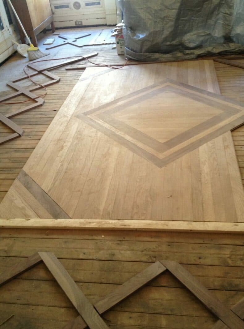 A partially installed hardwood floor featuring a diamond pattern.