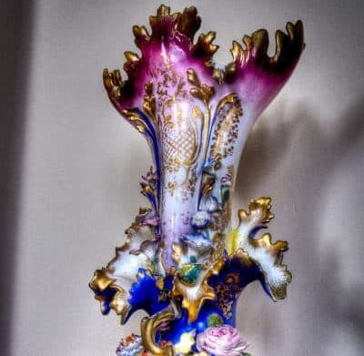 An ornate, multicolored vase featuring intricate floral designs and gold accents.