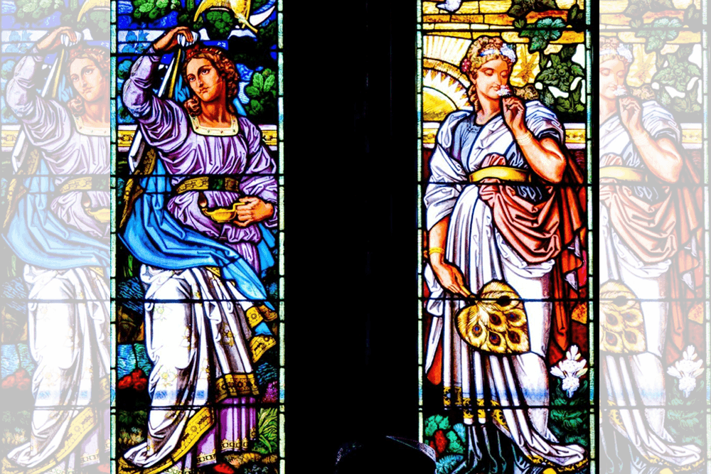 Colorful stained glass depicting four figures in flowing garments, two holding symbols of virtue.