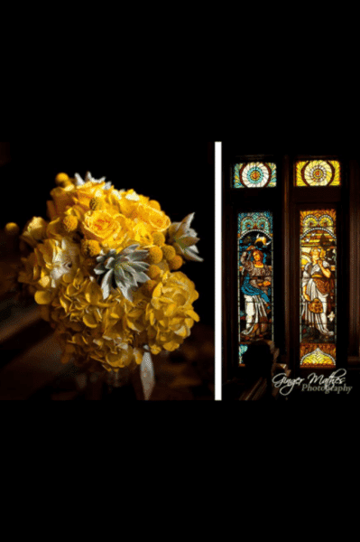 A vibrant yellow flower bouquet is paired with colorful stained glass windows.